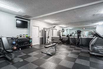 A well-equipped gym with a variety of exercise machines and weights